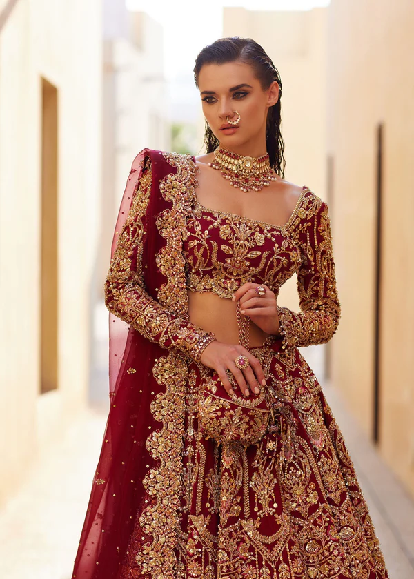 Maroon Bridal Lehenga with Gold Embroidery Elegant woman in traditional attire.
