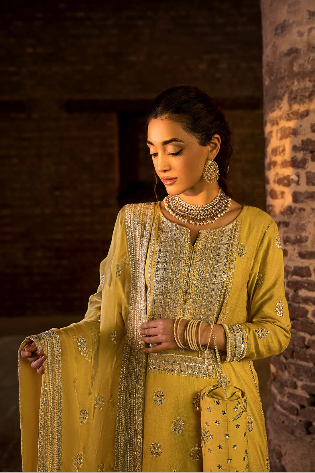 Designer Mustard Gold Ensemble with Intricate Handwork Elegant mustard-gold designer dress styled with statement jewelry.