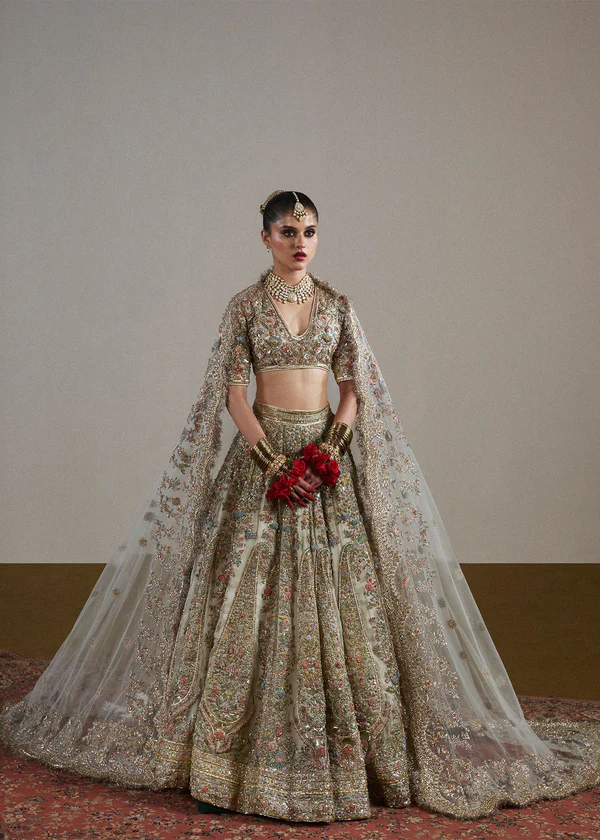 A detailed shot of a bride's red and gold lehenga with intricate lehenga designs, heavy embroidery, and traditional motifs.